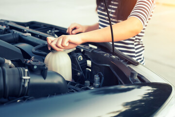 Check auto car's coolant level. That service, repair or maintenance by women hand to open cap of...