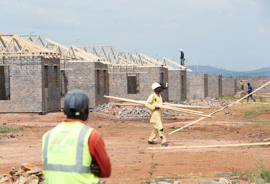 Workers are seen at a construction site at Protea Glen