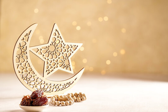 Ramadan kareem background . Golden Ramadan moon decor with Islamic rosary beads and dates fruit.
