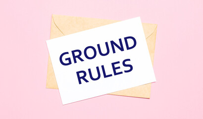 On a light pink background - a craft envelope. It has a white sheet of paper that says GROUND RULES.