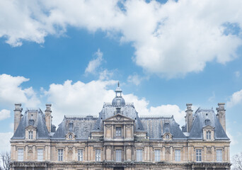 Fototapeta na wymiar Château de Maisons-laffitte côté jardin sur fond de ciel bleu et nuages