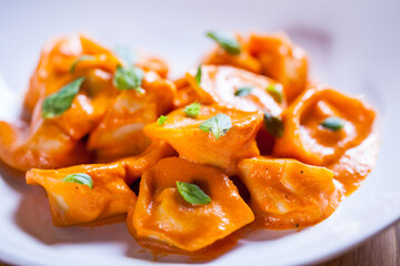 Delicious tortellini pasta in red tomato sauce with basil and parmesan cheese.
Tortellini pasta on white plare. Fine dish. Italian food
Home made fresh tortelini