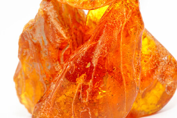 Transparent polished yellow amber on a white background. Sun stone. Natural mineral material for jewelry. Amber texture. Copal. Multicolored yellow background. Ancient fossil resin