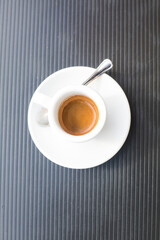 coffee couple with hot fresh espresso and metal tea spoon on grey plastic surface. Vertical geometrical composition. Top view to traditional italian beverage. Coffe break concept. Background picture. 