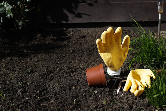 Preparation for gardening with yellow gloves and garden tools.