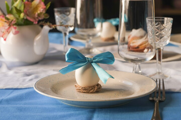 Beautiful holiday Easter table setting with flowers and eggs on linen tablecloth. Zero Waste Easter