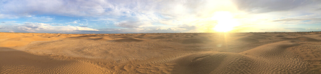 Fototapeta na wymiar Majestic panorama of landscape in the Sahara desert, Tunisia. Sun with bright rays over the desert horizon. Sand dunes against a beautiful sky