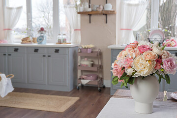 Coseup view on a blurred kitchen and flowers on a table
