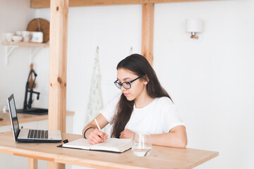 Young girl student doing homework with laptop at home, online learning, distance education