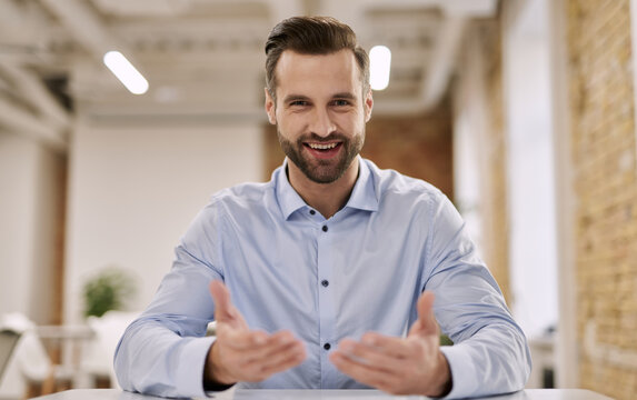 Mirthful office manager gesturing while talking at work