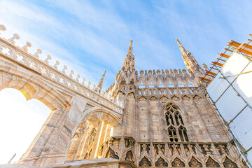 Roof of Milan Cathedral Duomo di Milano with Gothic spires and white marble statues. Top tourist...