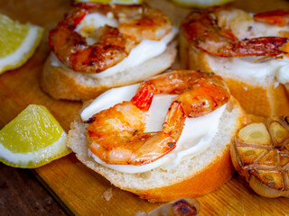 Delicious fried prawns on a skewer with sauce and lemon