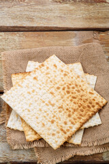 Matza sheets on top of each other lies on a wooden table.