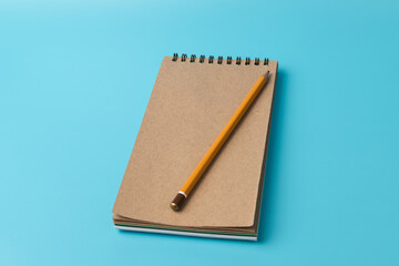 notebook,pencil, on blue background. top view copy space