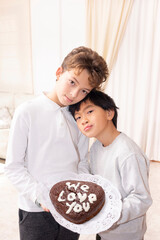 Two  multiracial family presenting cake with we love you