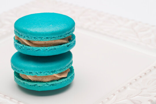 Two stacked blue macaroons filled with cinnamon cream