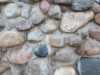 gray stone wall with cement, external wall of an old building, backgrounds