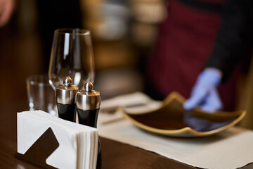 Rstaurant table with glasses and plates being set-up