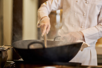 Professional chef working on a steamy wok