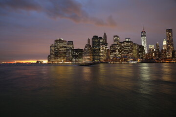 Fototapeta na wymiar Illuminated City At Waterfront During Sunset