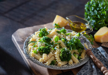 Fusilli with with broccoli, basil and parmesan cheese on a dark background. Proper nutrition. Sports nutrition. Dietary menu.