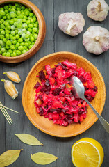 In the center of the plate is a fresh salad made from boiled and raw vegetables