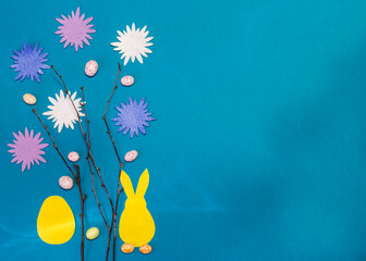 Fototapeta na wymiar easter card made with your own hands, a hare with an egg and branches with flowers with a copy of the space