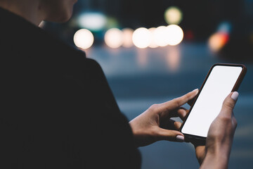 Woman messaging on cellphone in city park