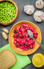 In a wooden plate, a small amount of vinaigrette made from fresh boiled vegetables and sauerkraut