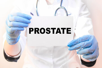 The doctor's blue - gloved hands show the word PROSTATE - . a gloved hand on a white background. Medical concept. the medicine