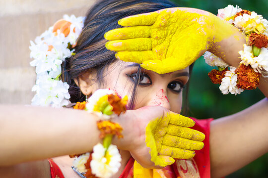 Pretty young indian girl showing colourful palm and celebrating Holi with colour splash, popular hindu festival celebrated across India. (Selective focus)
