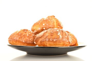 Several sweet chouquette on a saucer, close-up, isolated on white.