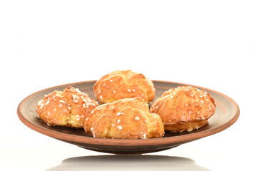 Several sweet chouquette on a clay plate, close-up, isolated on white.