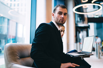 Manager sitting in office lounge with coworker