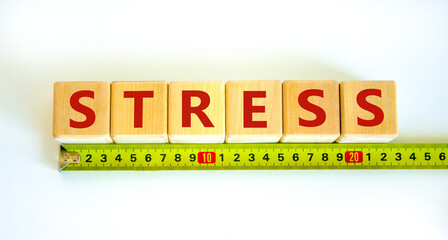 Stop stress and be health symbol. Wooden cubes with the word 'stress' behind yellow ruler. Beautiful white background. Psychological, business and stop stress concept. Copy space.