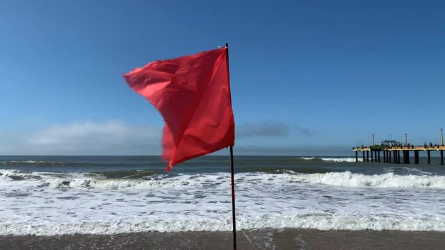Bandera roja flameando en la playa - Red flag flying on the beach