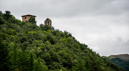 Fototapeta na wymiar Iglesia y santuario en el monasterio de Santo Toribio de Liébana, asomando entre la vegetación de la cordillera cantábrica española