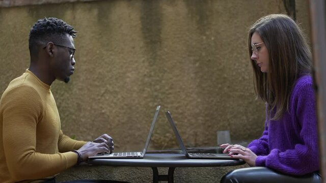Young interracial diverse couple using laptop computer working together
