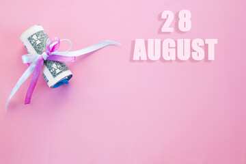 calendar date on pink background with rolled up dollar bills pinned by pink and blue ribbon with copy space. August 28 is the twenty-eighth day of the month