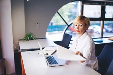 Wistful woman with papers and laptop