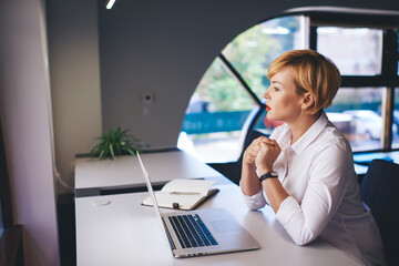 Wistful female worker with laptop during workday
