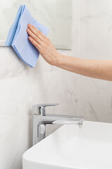 Woman with rag cleaning bathroom at home