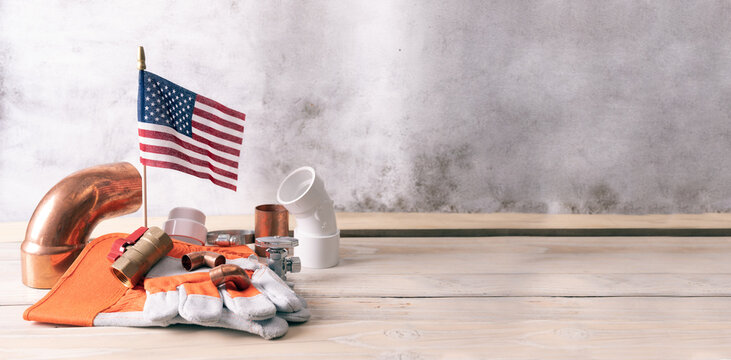 Construction and plumber tools with patriotic  American flag on old  background.
plumbing July 4th,
Independence Day of America. American symbol. 