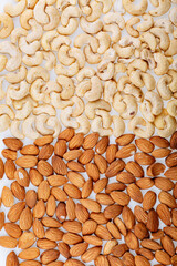 Pile of mixed organic nuts on white background. Mixe of various nuts background above closeup. Almond / Cashew mix.