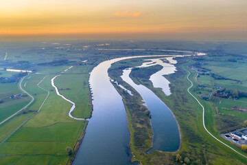 Lowland river IJssel through sunset landscape