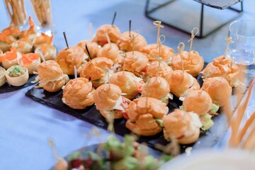 Close up view of portion small delicious snacks on the party.