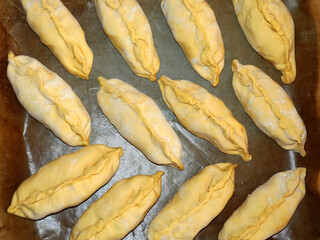 raw small pies on a baking sheet for food background