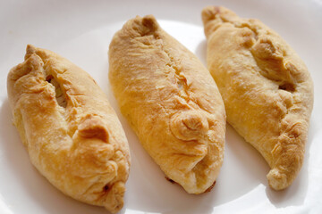 baked small pies on a white plate close-up
