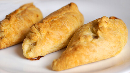 baked small pies on a white plate close-up