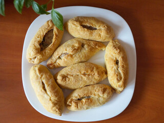 baked small pies on a white plate close-up